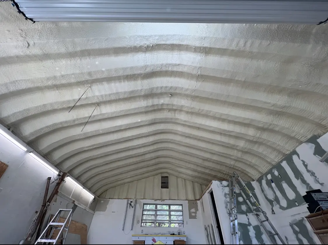 Spray polyurethane foam applied to the underside of a metal roof deck in Delhi